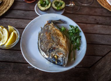 Balık yemi limon ile beyaz plaka üzerinde.