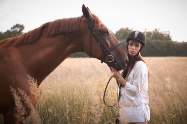Kahverengi at ile beyaz kısa içinde esmer kadın.