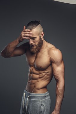 Gömleksiz kaslı vücut geliştirmeci sakallı 