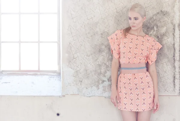 Pembe elbiseli sarışın erkek portresi.