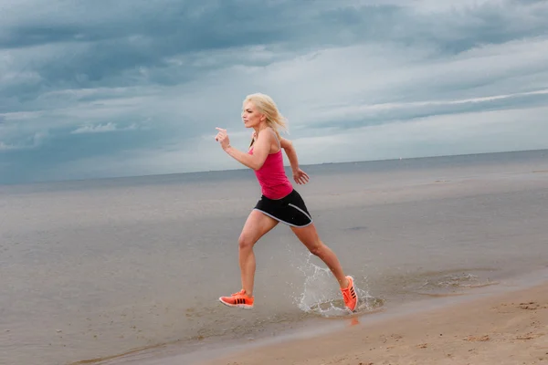 Blonďatá žena v sportovní běží — Stock fotografie