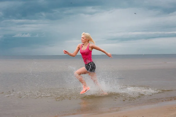 Blond female in sportswear running — Stock Photo, Image