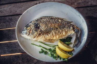 Beyaz plaka üzerinde ızgara balık.