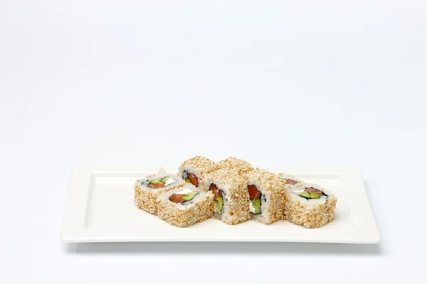 Кусочки суши на белой керамической пластине . — стоковое фото