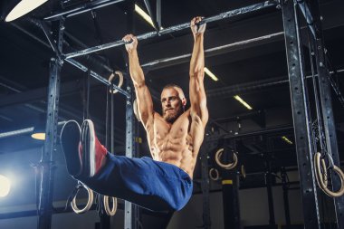 Kas gömleksiz adam yukarı çekerek yapıyor.