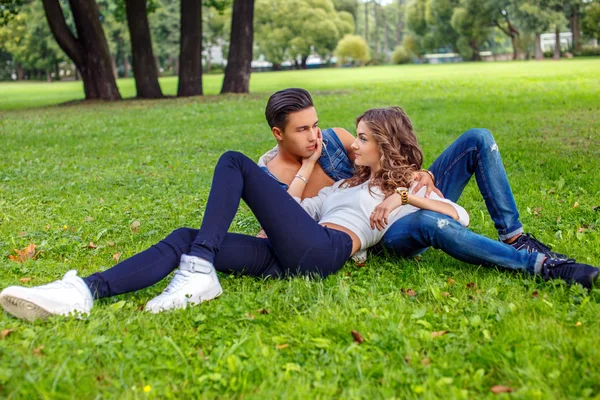 Casual masculino e feminino deitado na grama — Fotografia de Stock