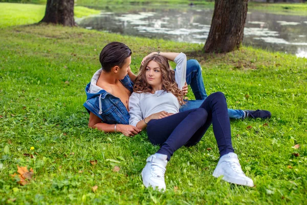 Casual mannelijke en vrouwelijke liggen op gras — Stockfoto