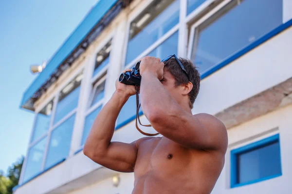 Hombre mirando a través de binocular . — Foto de Stock