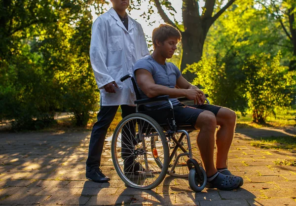 Guy en fauteuil roulant se reposant dans le parc . — Photo