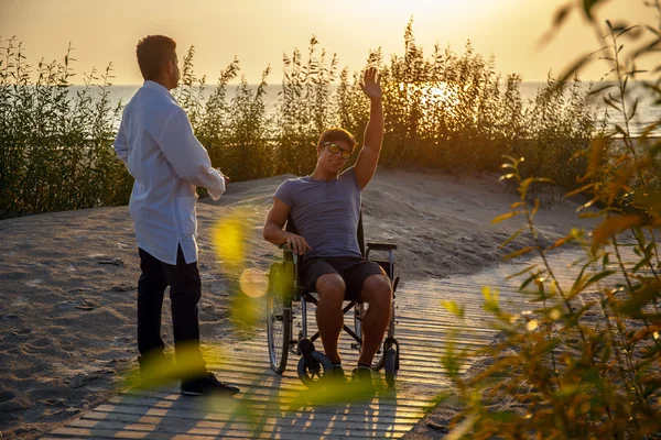 Молодой человек в инвалидной коляске и его врач . — стоковое фото