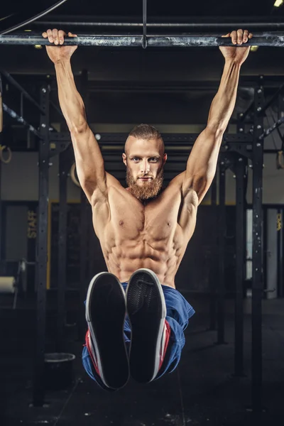 Culturista con barba facendo pull up . — Foto Stock