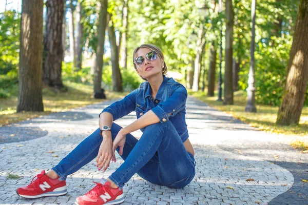 Smal tjej i jeans kläder och röda skor. — Stockfoto