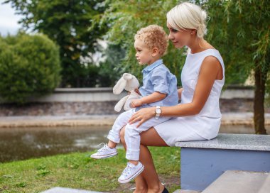 Küçük çocuk annesi dizlerinin üstünde oturan