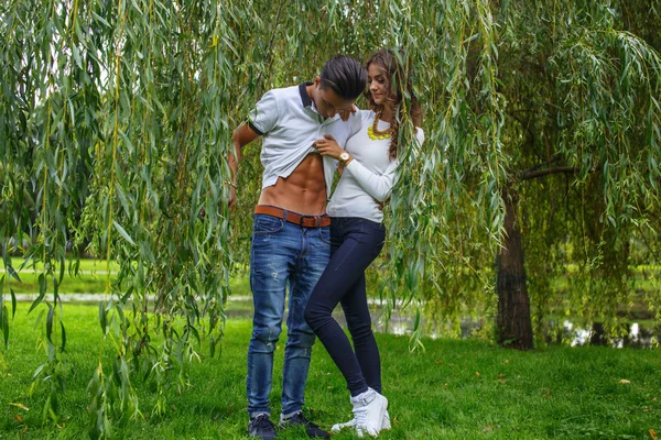 Beautiful young couple under green tree. — Stock Photo, Image