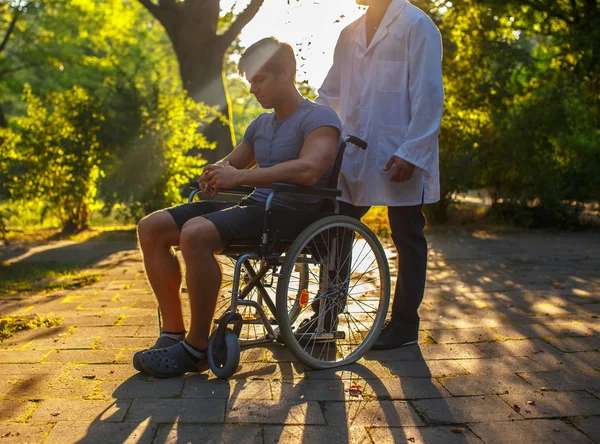 Adam tekerlekli sandalye ve onun doktor — Stok fotoğraf