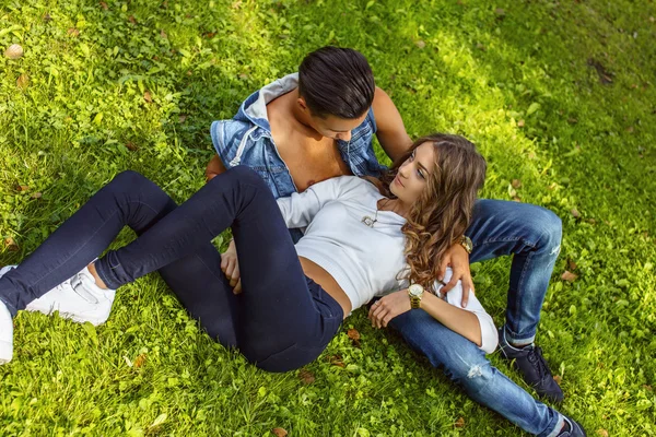 Ungt par liggande på gräsplan. — Stockfoto