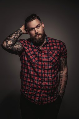 Sakal ve başını tutan dövmesi olan adam.