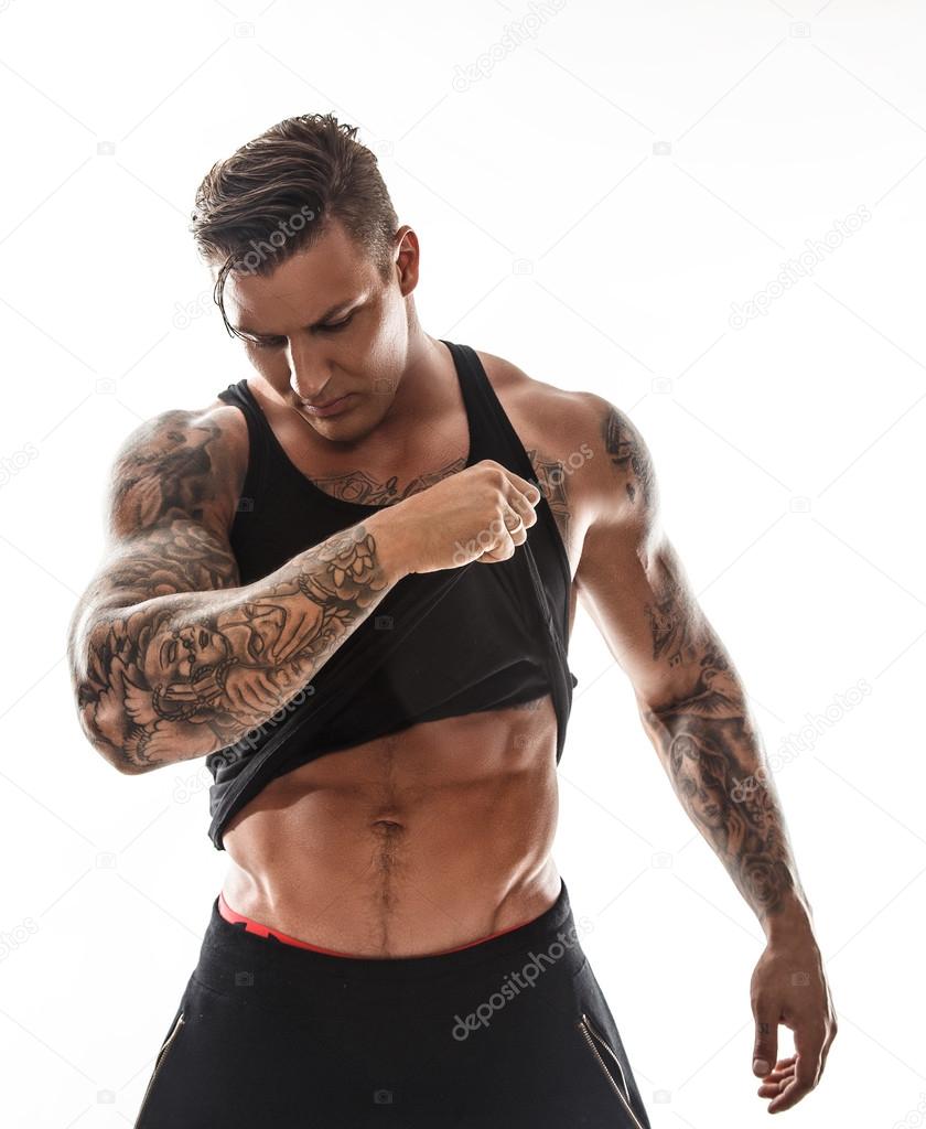 Tattooed man putting out his shirt.