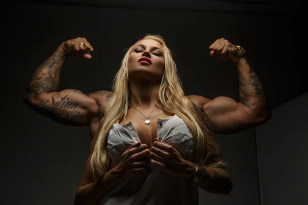Sexy blonde Frau und muskulöse Kerl hinter ihr. — Stockfoto