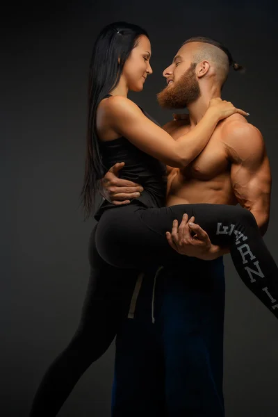 Man die op wapens zijn atletische vrouw. — Stockfoto