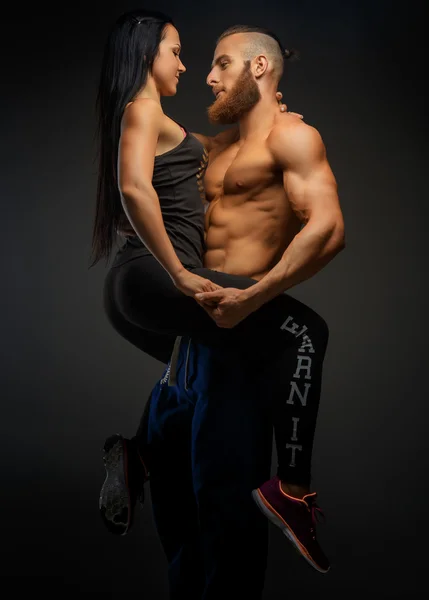 Man die op wapens zijn atletische vrouw. — Stockfoto