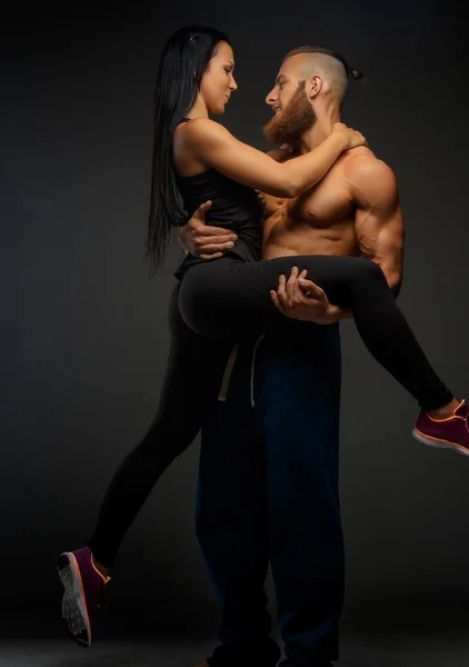 Man die op wapens zijn atletische vrouw. — Stockfoto