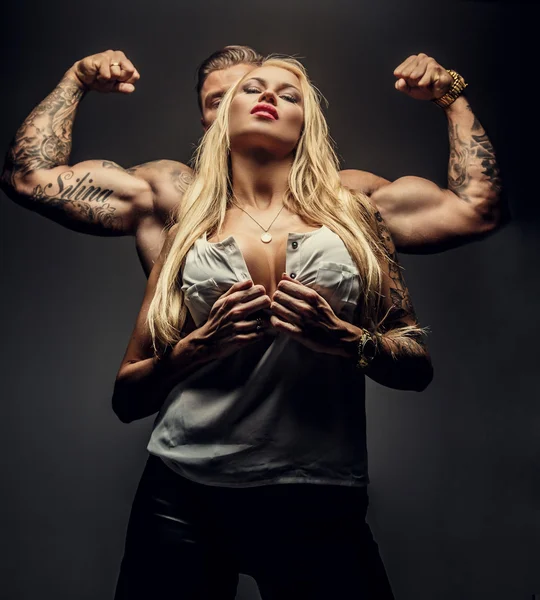 Blond female and muscular male behind her. — Stock Photo, Image