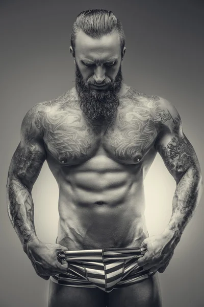 Svartvit bild av muskulösa tatuerade mannen. — Stockfoto