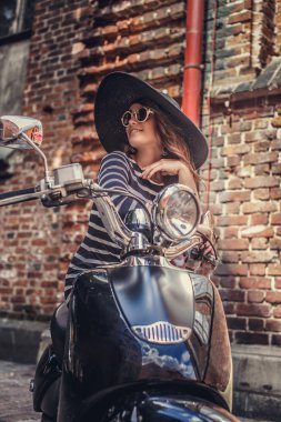 Moto scooter üzerinde oturan kadın.