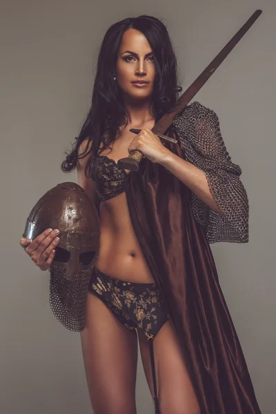 Kvinna med encient hjälm och svärd. — Stockfoto