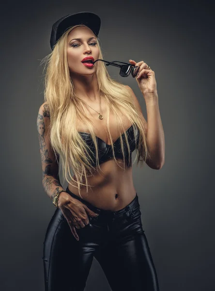 Sexig blond kvinna i svart latex byxor. — Stockfoto