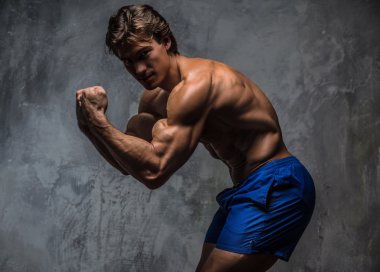 Güçlü kas vücut geliştirmeci vücudunu gösteren.