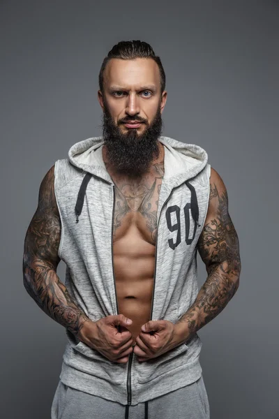 Muscular tattooed man with beard. — Stock Photo, Image