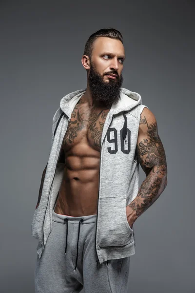 Muscular tattooed man with beard. — Stock Photo, Image