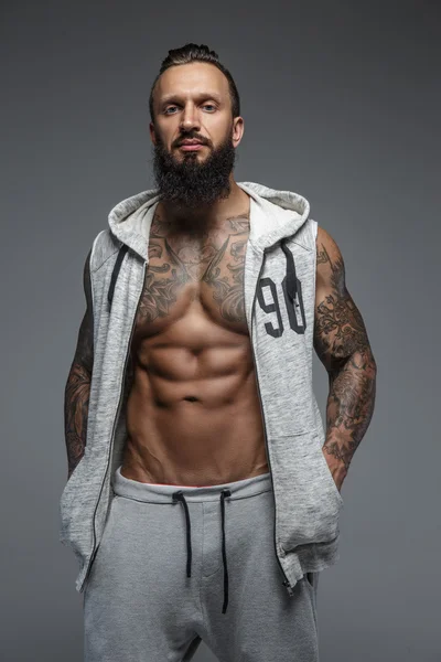 Muscular tattooed man with beard. — Stock Photo, Image