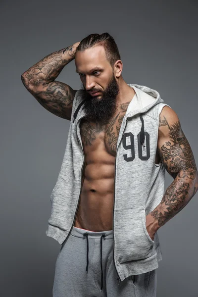 Muscular tattooed man with beard. — Stock Photo, Image