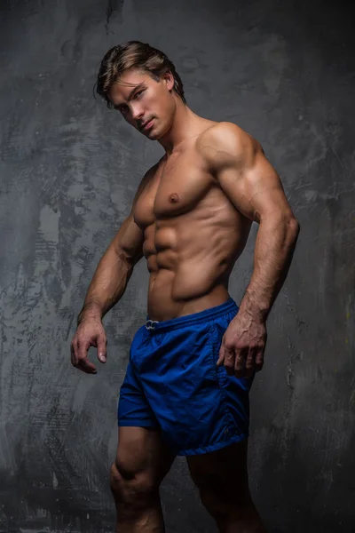 Przystojny mięśni mężczyzna w niebieskim spodenki. — Zdjęcie stockowe