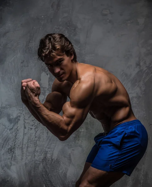 Bello muscoloso maschio in pantaloncini blu . — Foto Stock
