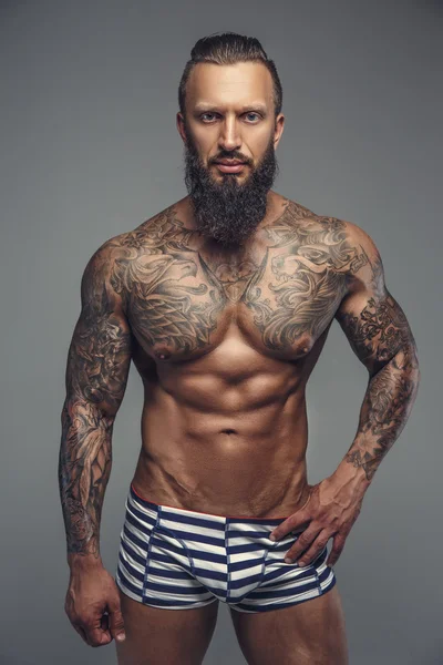 Βάναυση τατουάζ άνθρωπος στις λωρίδες κιλότες. — Φωτογραφία Αρχείου