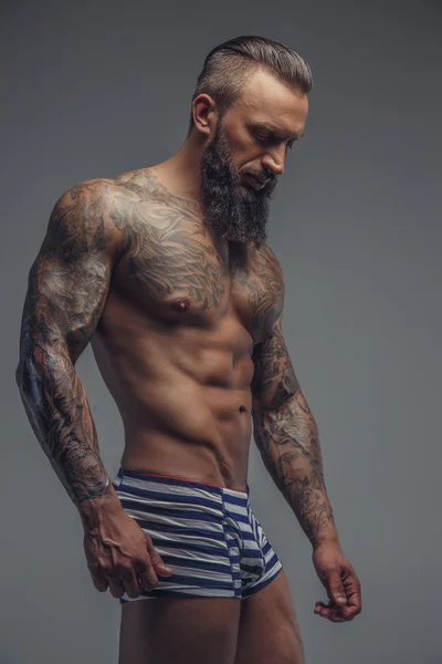 Brutale tatuato uomo in ombre . — Foto Stock