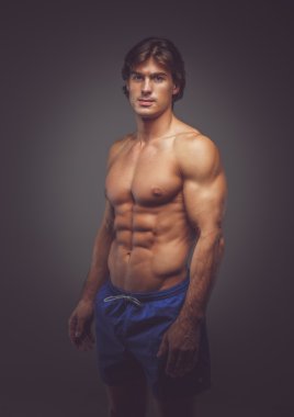 Gömleksiz kaslı adam mavi şort.