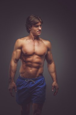 Gömleksiz kaslı adam mavi şort.