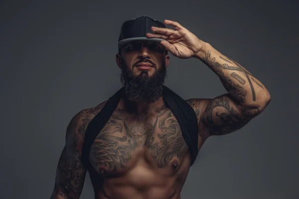Brutal hombre tatuado en gorra negra . — Foto de Stock