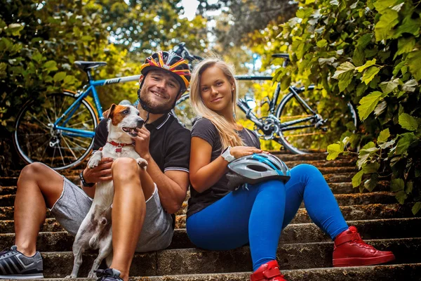 Мужчина и женщина с собакой на двух велосипедах . — стоковое фото