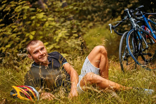 Hombre acostado en la hierba en el bosque . — Foto de Stock