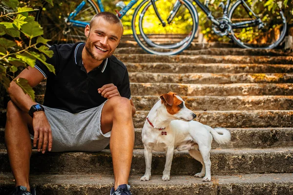 Merdivenlerde oturan köpekli adam. — Stok fotoğraf