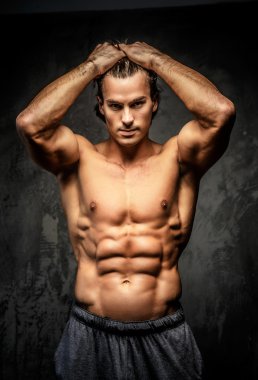 Kafasını tutarak çıplak vücut geliştirmeci.