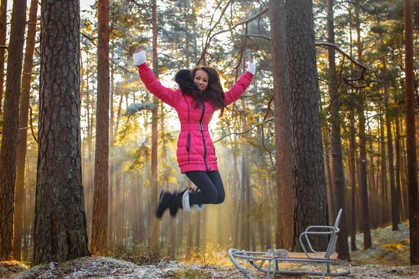 Girl in pink coat jumps. — Stock Photo, Image