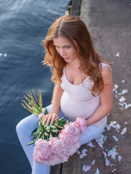 ピンクの花束と妊娠中の女性. — ストック写真