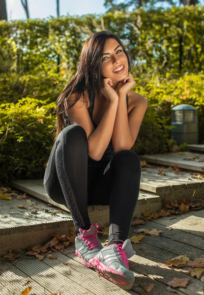 Fitness woman sits on steps. — Stock Photo, Image